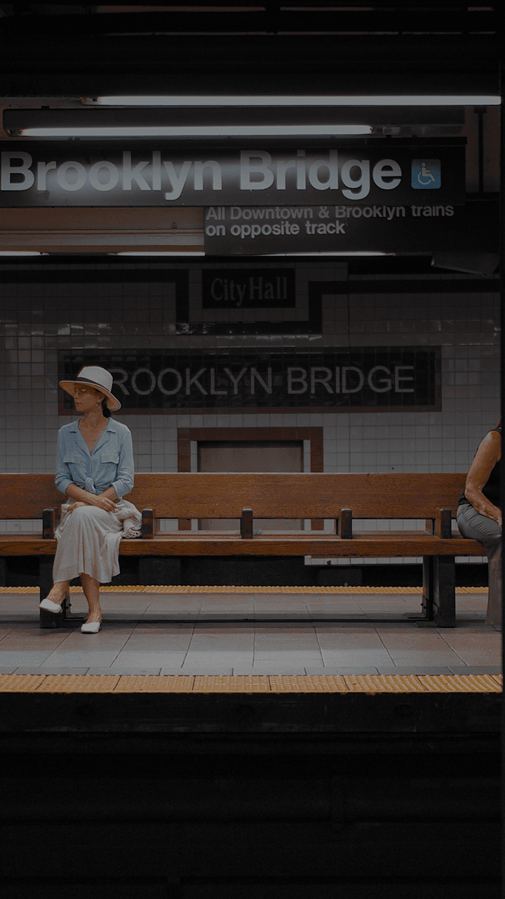 Uma mulher sentada em um banco em uma estação de metrô