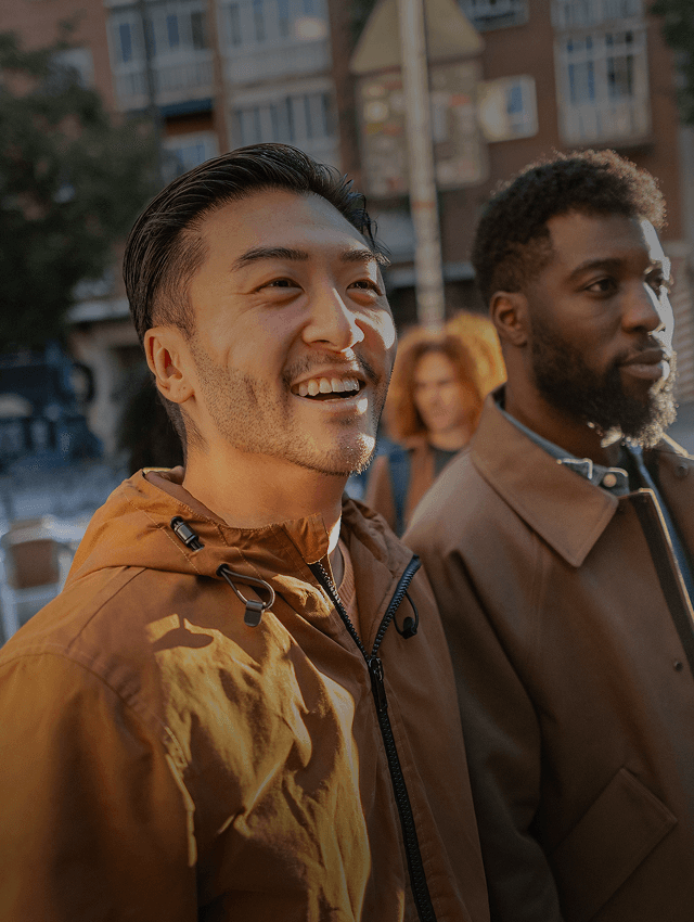 Amigos sorridentes caminham por uma rua em um novo país.