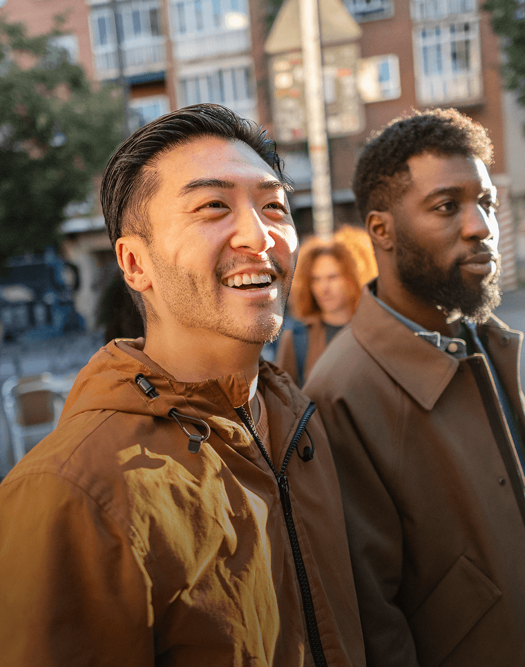 Amigos sorridentes caminham por uma rua em um novo país.